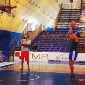 Archie con in braccio il piccolo Jordan assiste all'allenamento della moglie